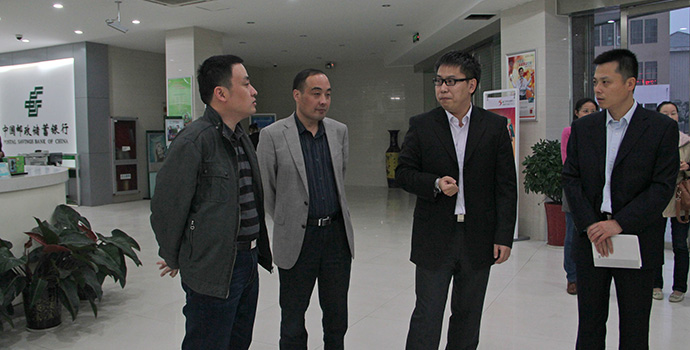 安徽邮储省行电子银行部阎松华总经理（右一）、合肥市行行助丁小平（左一）听取网点转型情况汇报